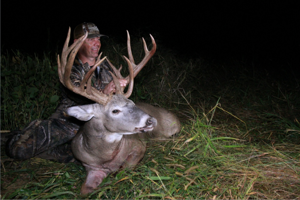 Hunter holding Giant Buck that got big by eating Deer Minerals